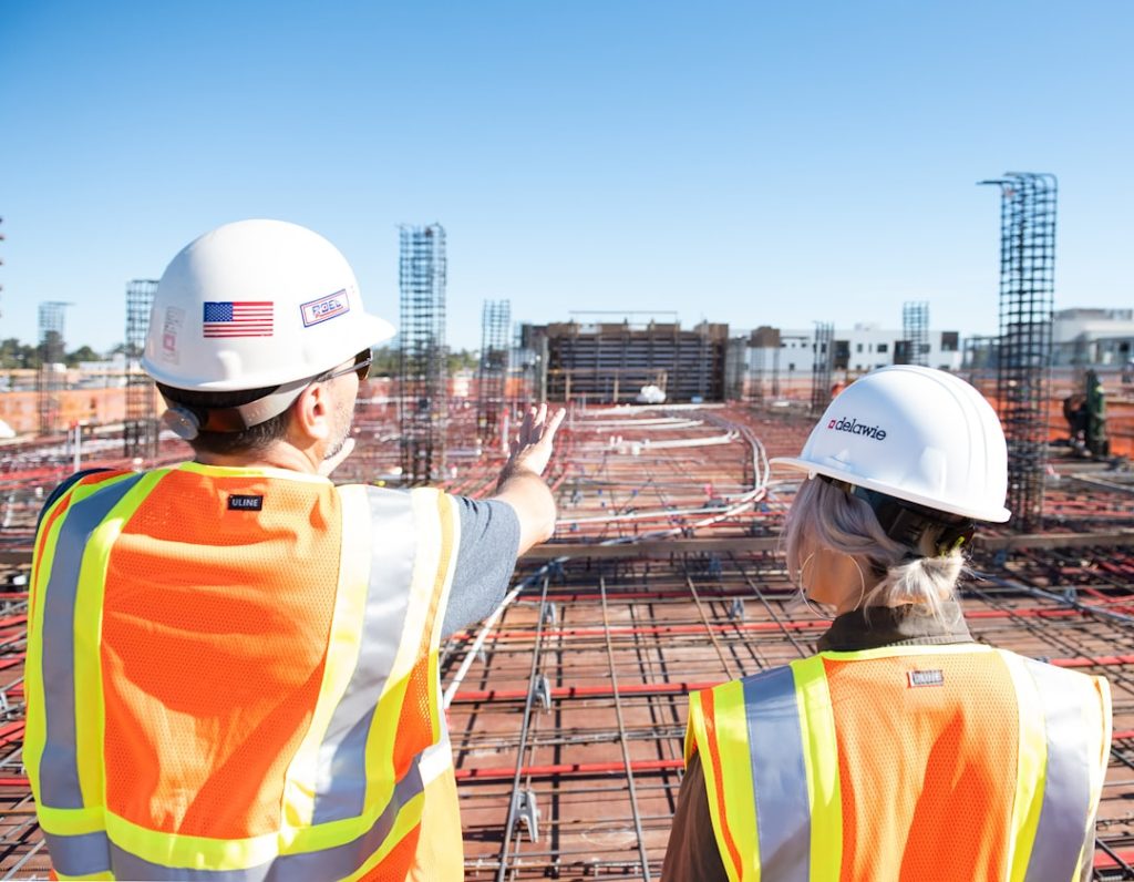 two-construction-workers-in-safety-vests-at-site-80zz1s24nag