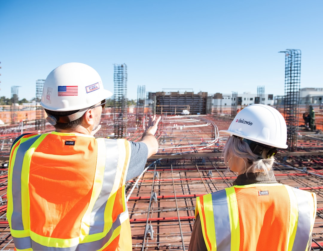 two-construction-workers-in-safety-vests-at-site-80zz1s24nag